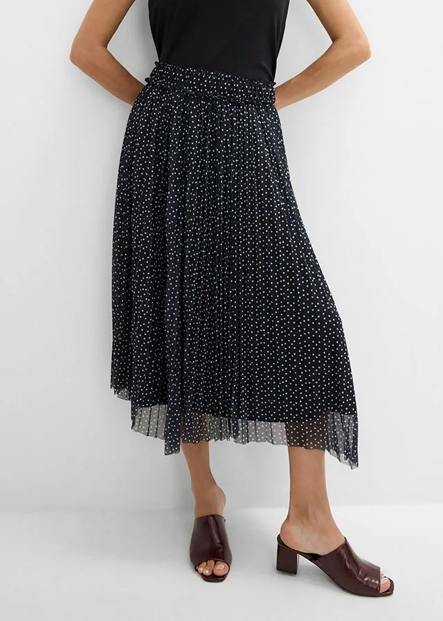 Black top, polka-dot pleated skirt and brown sandals